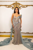 Elegant off-the-shoulder mermaid evening gown in shimmering sage green sequins with intricate floral embroidery, sheer illusion details, asymmetric straps, and flowing chiffon train.