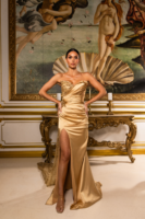 Elegant strapless champagne satin evening gown with asymmetrical ruched bodice, gold floral embroidery and embellishments, high side slit, and flowing train, modeled in a luxurious setting inspired by Botticelli's Venus.