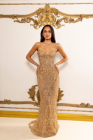 Model wearing a strapless champagne gold evening gown with intricate beadwork, embroidery, and crystal embellishments in floral patterns, featuring a fitted mermaid silhouette and small train.